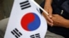 Seorang veteran perang Korea Selatan memegang bendera nasional dalam upacara memperingati 70 tahun Perang Korea, di dekat zona demiliterisasi yang memisahkan kedua Korea, di Cheorwon, Korea Selatan, 25 Juni 2020. (Foto: REUTERS/Kim Hong-Ji )