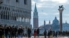 People walk through across a makeshift walkway over the flooded St. Mark's Square in Venice, Italy.