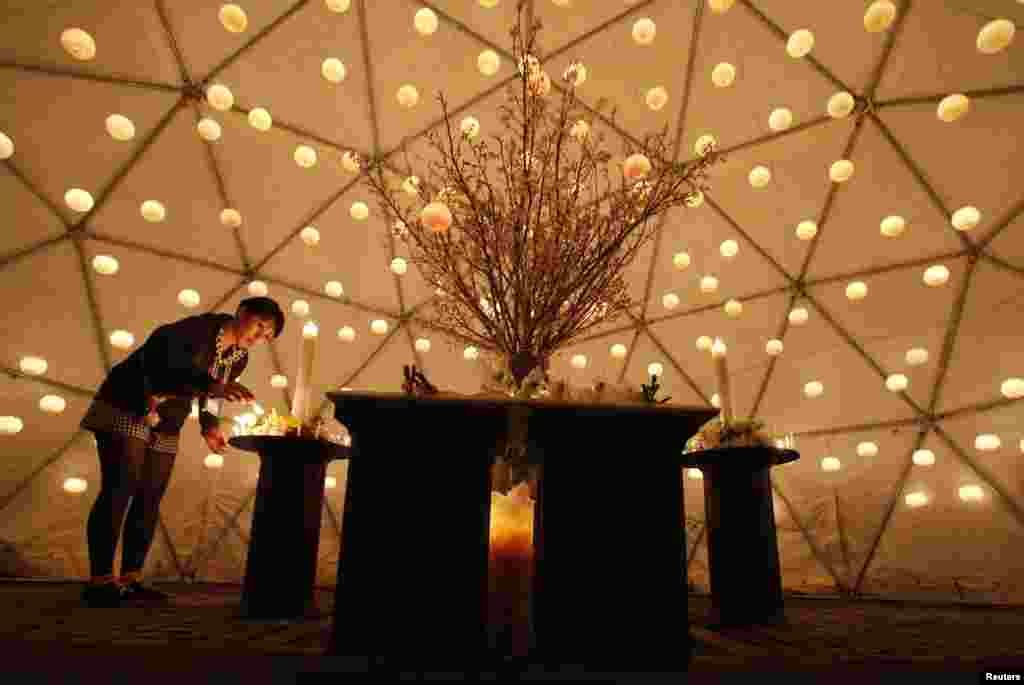 Seorang pengunjung menyalakan lilin untuk menghormati para korban gempa bumi dan tsunami 11 Maret 2011 di Tokyo (11/3).