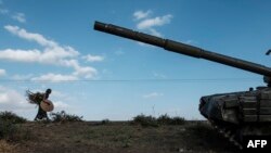 Mwanamke akitembea karibu na kifaru jeshi cha vikosi vya Tigray, Desemba 11, 2020.