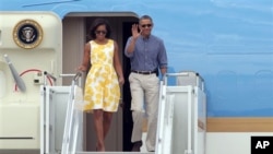 Presiden Barack Obama dan Ibu Negara Michelle Obama tiba di Bandara Garda Pantai Coast Guard di Bourne, Massachussets (10/8).