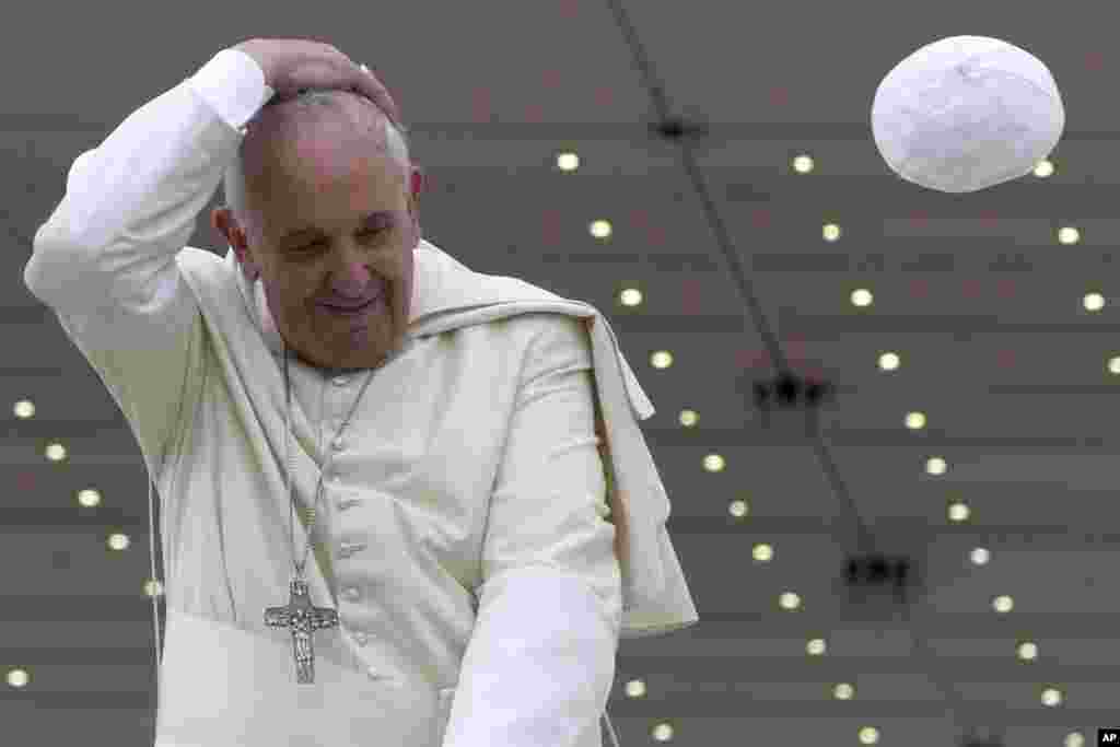 A gust of wind blows away Pope Francis&#39; cap as he leaves at the end of his weekly general audience, at the Vatican.