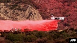 An aircraft drops retardant on a mountainside as the Franklin Fire burns in Malibu, California, on Dec. 11, 2024.