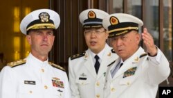 美国海军作战部长理查森上将在北京的中国海军总部听取时任中国海军司令员的吴胜利上将介绍情况。（2016年7月18日）