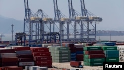 Sebuah truk melintasi peti kemas di pelabuhan Ningbo, provinsi Zhejiang (9/7). Ekspor China turun 3,1 persen bulan Juni tahun 2013, memicu keprihatinan terkait melemahnya pertumbuhan ekonomi di negara kedua terbesar ekonomi dunia tersebut.