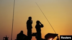 以色列士兵11月20日站在加沙以北的一辆炮车上