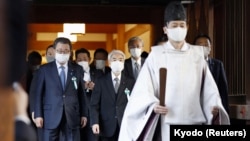 A Shinto priest accompanies a group of Japanese lawmakers as they visit the Yasukuni shrine to pay respects to the country's war dead in Tokyo, Japan, Dec. 7, 2021