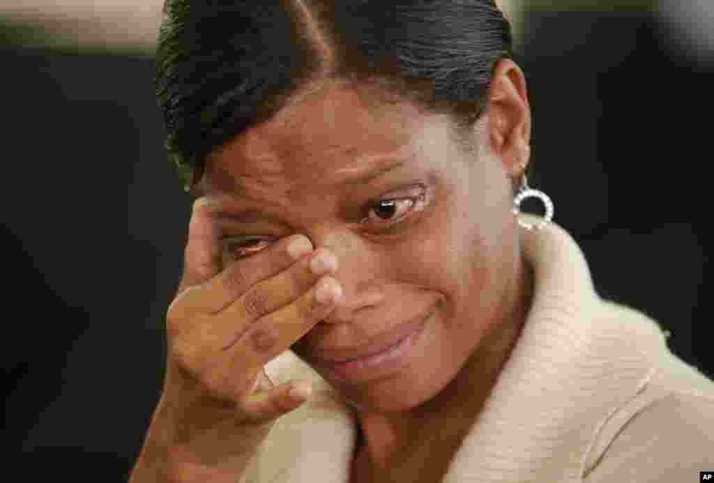 Seorang perempuan menghapus airmatanya ketika menyaksikan upacara pemakaman mantan presiden Nelson Mandela di layar besar di Yayasan Nelson Mandela Foundation di Johannesburg. 