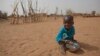FILE - А boy is seen eating dry couscous in the village of Goudoude Diobe, in the Matam region of northeastern Senegal.