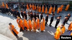 Policemen and Buddhist monks walk inside Dhammakaya temple to search for a fugitive Buddhist monk in Pathum Thani province, Thailand, Feb. 17, 2017.