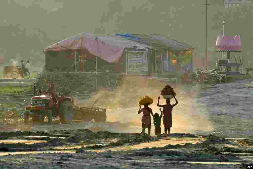 Pekerja India membawa kotoran sapi di atas kepala mereka di kota Allahabad. Kotoran sapi kering digunakan sebagai bahan bakar untuk memasak di daerah perdesaan di India. 