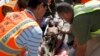 FILE - U.N and other aid personnel assist a wounded young man after he and others were airlifted to Mogadishu for treatment, following attacks on two restaurants in the city of Baidoa, at the airport in Mogadishu, Somalia, Feb. 29, 2016. 