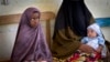 A Somali mother and her older child wait in line for her baby to receive a five-in-one vaccine against several potentially fatal childhood diseases, at the Medina Maternal Child Health center in Mogadishu, Somalia Wednesday, April 24, 2013. (AP Photo/Ben) 