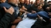 Janda dari Hamza Wael Dahdouh, seorang jurnalis jaringan televisi Al Jazeera, berduka memeluk jasadnya saat pemakamannya, setelah ia dilaporkan tewas dalam serangan udara Israel di Rafah, Jalur Gaza (foto: dok). 