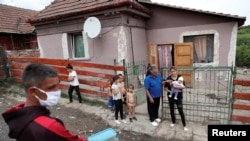 FILE – A Roma activist carries food donations during the COVID-19 outbreak in Miskolc, Hungary, April 30, 2020. Roma leaders are urging the government to do more to intervene and tackle what has been described as a humanitarian crisis.
