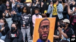 Picha ya George Floyd ikizungukwa na watu wa rangi tofauti huko Minneapolis, Minnesota