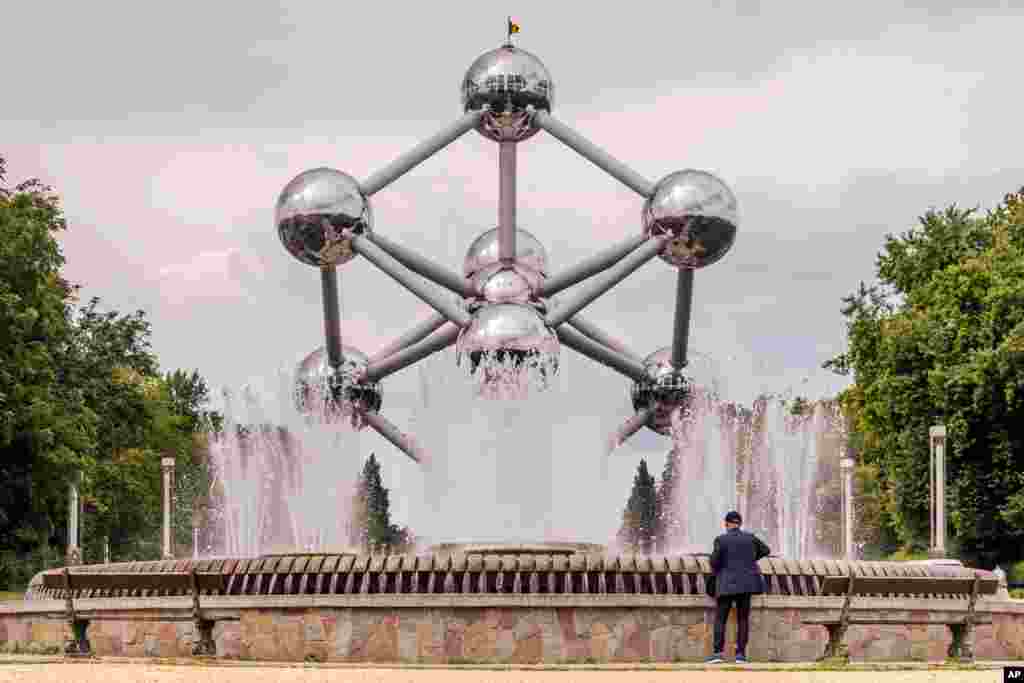 Turis mengamati air mancur di Atomium di kota Brussels, Belgia.