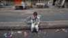 A child sits along a road median as he eats his breakfast of a single piece of "roti" (South Asian bread) while waiting for work in Karachi early morning May 6, 2012.