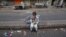 A child sits along a road median as he eats his breakfast of a single piece of "roti" (South Asian bread) while waiting for work in Karachi early morning May 6, 2012.