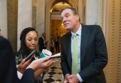 FILE - Sen. Mark Warner, D-Va., pauses to speak with reporters at the Capitol in Washington, June 10, 2021.