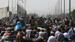 阿富汗人聚集在喀布尔机场军事区附近的一条道路旁，希望逃离塔利班的统治。(2021年8月20日)