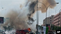Smoke and debris fill the sky seconds after a car bomb explodes alongside firemen responding to an initial car bomb that had exploded five minutes earlier, in Abuja, Nigeria, 01 Oct 2010
