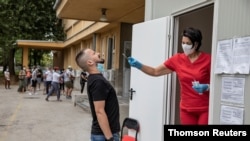 A man reacts while getting a coronavirus disease (COVID-19) swab test in Belgrade, Serbia, Aug. 12, 2020.