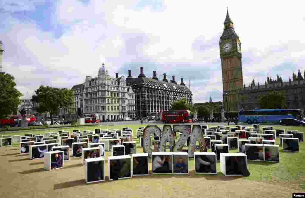 Orang-orang duduk di kotak kayu untuk menunjukkan kehidupan di Gaza, dalam sebuah protes, Parliament Square, London, 14 Agustus 2014.