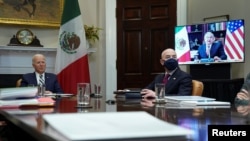 U.S. President Joe Biden and Homeland Security Secretary Alejandro Mayorkas listen during a virtual bilateral meeting with Mexican President Andres Manuel Lopez Obrador from the White House in Washington, March 1, 2021. 