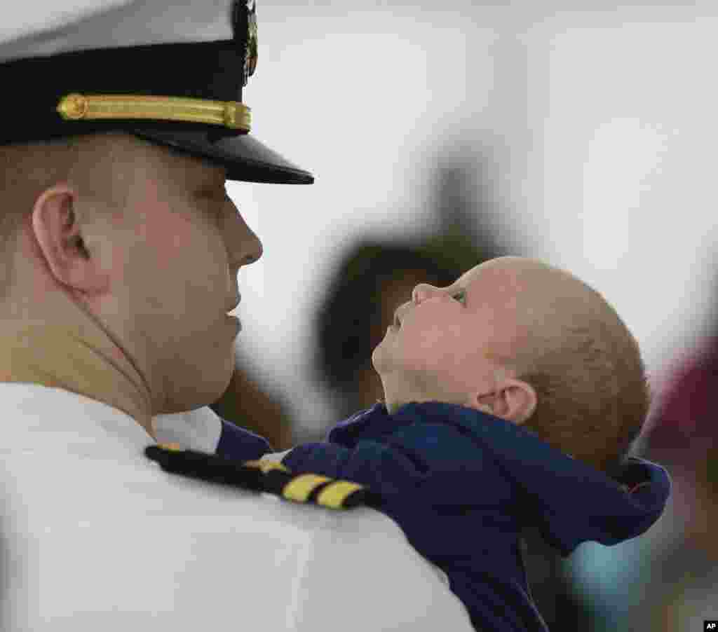Ewan Bingham, bayi berusia enam minggu ini mengamati ayahnya, Lt. Chris Bingham dari Cranford, New Jersey, setelah sang ayah turun dari kapal USS Harry S. Truman di Norfolk, Virginia. Anggota Armada Angkatan Laut Amerika itu kembali dari penugasan selama sembilan bulan. Sejumlah 171 bayi lahir dari para anggota angkatan laut itu selama masa penugasan mereka. &nbsp;