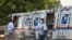 Postal workers load packages in their mail delivery vehicles at the Panorama city post office on Aug. 20, 2020 in the Panorama City section of Los Angeles.
