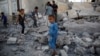 FILE - Children play amid the rubble of a house destroyed by a Saudi-led airstrike in Sana'a, Yemen, Sept. 8, 2015. A cease-fire declared two months ago has not slowed the violence the Yemen, local activists say.