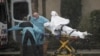 Medics transport a patient through heavy rain into an ambulance at Life Care Center of Kirkland, the long-term care facility linked to several confirmed coronavirus cases in the state, in Kirkland, Wash., March 7, 2020. 