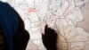 FILE - Evalina, a South Sudanese teenage victim of sexual abuse, points on a map to Unity state, indicating where she used to live, March 9, 2015. She said she escaped to Khartoum after being imprisoned by gunmen and sexually abused for two months.