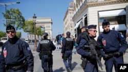 法国警察和震暴警察（右）４月２１日在巴黎的香榭丽舍大道巡逻
