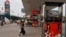 FILE PHOTO - A woman walks through a closed Caltex gas station during a strike Monday, May 12, 2014, in Phnom Penh, Cambodia.