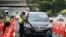 Seorang polisi memeriksa mobil di sebuah pos pemeriksaan ketika para pemudik kembali ke ibu kota di tengah pandemi COVID-19, di Cikarang, Bekasi, 17 Mei 2021. (REUTERS/Ajeng Dinar Ulfiana)
