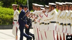 日本首相安倍晋三（中）、防卫大臣河野太郎（右）在东京准备检阅仪仗队。（2019年9月17日）