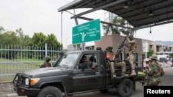 Des rebelles du M23 lors du transport de membres présumés des FDLR capturés (non photographiés) vers le Rwanda, au poste frontière de la Grande Barrière de Goma-Gisenyi, le 1er mars 2025.