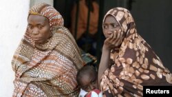 Women sit with their children at a camp for internally displaced people in Nigeria's central city of Jos. 