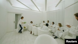 FILE - In Sweden, where lack of winter sunlight can contribute to depression, customers dressed in white robes take in simulated sunlight at Stockholm's Iglo Ljuscafe, Dec. 12, 2006.