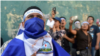 Manifestantes antigubernamentales entonan el himno nacional de Nicaragua el 25 de abril de 2018 frente a la sede de la policía nacional en Managua © AFP RODRIGO ARANGUA