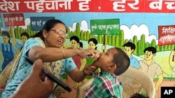 Seorang petugas kesehatan tengah memberikan vaksin polio di sebuah sekolah di New Delhi, India (7/4).