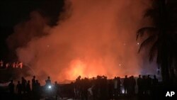 People work to put out a fire in a makeshift market near a Rohingya refugee camp in Kutupalong, Bangladesh, Friday, April 2, 2021. The fire broke out early Friday when residents of the sprawling Kutupalong camp for Myanmar's Rohingya refugees were…