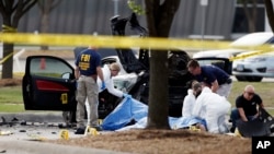 4일 미국 텍사스 주 총격 현장에서 FBI 수사관들이 경찰에 사살된 용의자와 용의자 차량 주변을 조사하고 있다.
