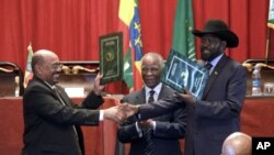 Sudan's President Omar al-Bashir, left, and South Sudan President Salva Kiir, right, shake hands on the completion of a signing ceremony after the two countries reached a deal on economic and security agreements in Addis Ababa, Ethiopia, Sept. 27, 2012. 