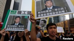 香港民主示威者举着香港特首梁振英像和质问他的口号游行（2014年10月22日）