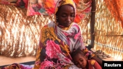 FILE - Hanan Idriss, a mother of two, speaks in the border town of Adre, Chad, Nov. 14, 2023. Idriss said RSF and Arab militiamen attacked her house in Ardamata, Sudan, and tried to sexually assault her and her sister. Women's rights dwindled last year, a U.N. report says.