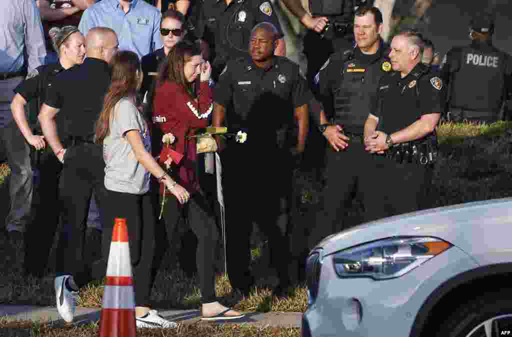 បុគ្គលិក ​គ្រូបង្រៀន​ និងសិស្ស​ជាច្រើន​ដែល​បាន​ត្រឡប់ចូល​វិទ្យាល័យ​​ Stoneman Douglas វិញ​ត្រូវ​បាន​ស្វាគមន៍​ដោយ​ប៉ូលិស​ក្នុង​ទីក្រុង​ Parkland​ រដ្ឋFlorida។