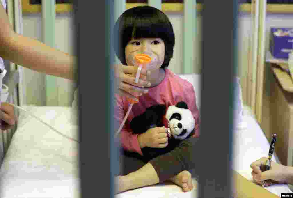 2015年12月21日，在北京第二次发布空气污染红色警报后第三天， 两岁儿童Pengpeng在北京新世纪国际儿童医院接受雾化疗法（nebulizer therapy）治疗